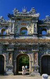 Emperor Gia Long ordered the construction of Hue Citadel in 1805. The vast complex is built according to the notions of fengshui or Chinese geomancy, but following the military principles of the noted 18th century French military architect Sebastien de Vauban. The result is an unusual and elegant hybrid, a Chinese-style Imperial City carefully aligned with surrounding hills, islands and waterways, but defended by massive brick walls between 6-12 metres high and 2.5 metres thick, punctuated by towers, ramparts, a massive earth glacis, and 24 Vauban-inspired bastions.<br/><br/>The entire complex was further protected by wide moats, crossed by gracefully arched stone bridges leading to ten gates, the chief of which is Cua Ngo Mon, the south-east facing ‘Meridian Gate’. To compound the exotic hybrid effect, guard posts designed as Chinese-style miradors, complete with sweeping eaves crowned by imperial dragons, surmounted each gate. Finally, directly in front of the Ngo Mon Gate, a massive brick fort 18 metres high was constructed both as an additional barrier against malign spirits, and as a defensive redoubt.<br/><br/>The area within the Citadel - in all, 520 hectares (1300 acres) - comprises three concentric enclosures, the Civic, Imperial and Forbidden Purple Cities. Access is by way of ten fortified gates, each of which is reached by a low, arched stone bridge across the moat. In imperial times a cannon would sound at 5am and 9pm to mark the opening and closing of the gates.<br/><br/>Hue was the imperial capital of the Nguyen Dynasty between 1802 and 1945. The tombs of several emperors lie in and around the city and along the Perfume River. Hue is a UNESCO World Heritage Site.